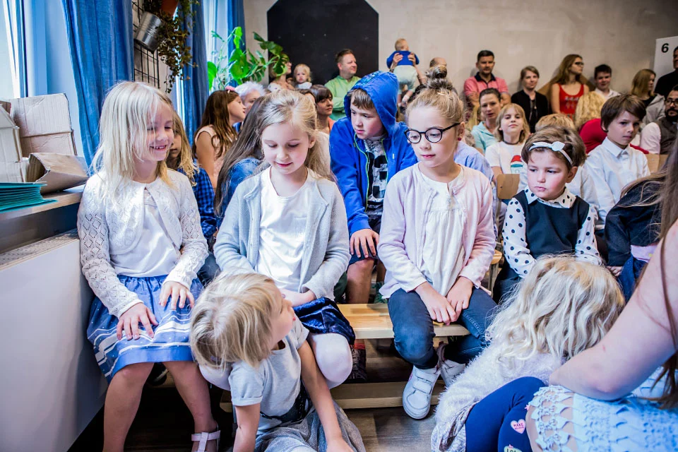 Uczniowie na ławkach podczas szkolnego spotkania z rodzicami